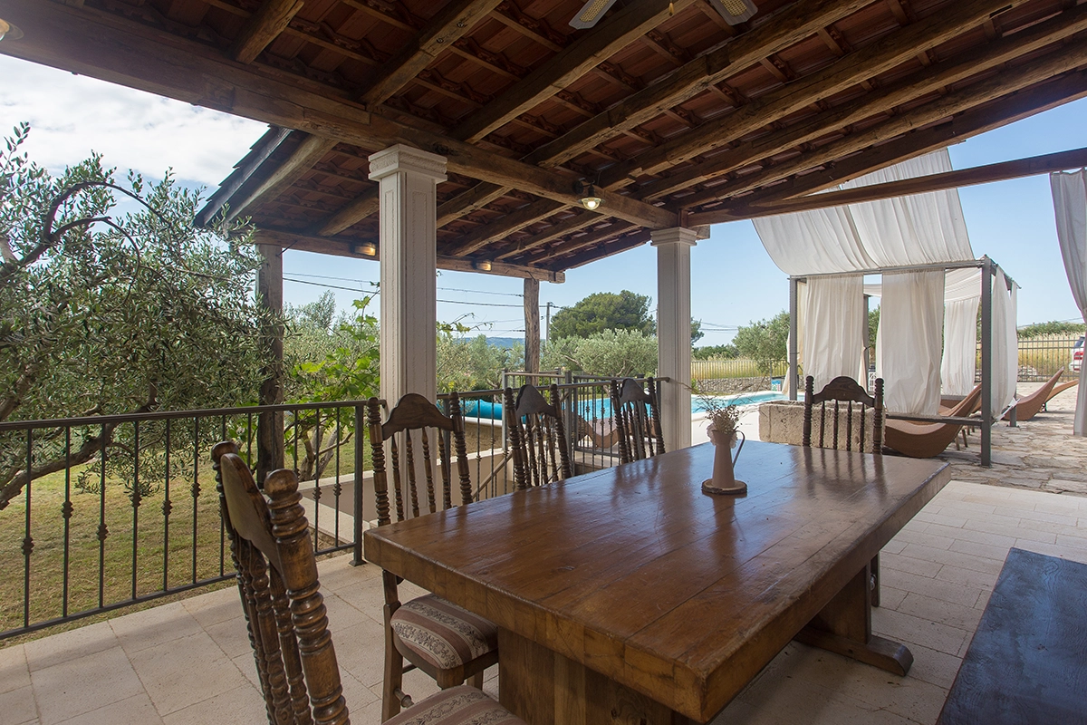 Outdoor wooden dining table in front of the villa.